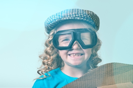 happy child girl playing with toy airplane. the dream of becoming a pilotの写真素材
