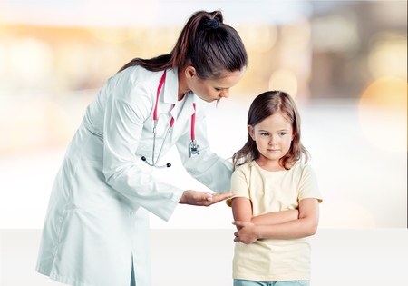 health care, people, children and medicine concept - close up of doctor giving capsules of cod-liver oil to happy girl at hospitalの写真素材