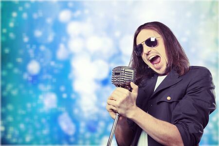 Retro image of man singing into microphoneの写真素材