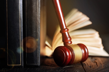 Wooden gavel and books on wooden table, law concept