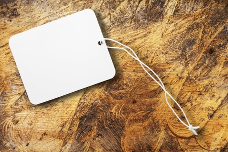 Blank white plastic badge. Template for ID. Blank badge on vintage wooden table background. Mock-up for branding identity for designers. Top view.の写真素材