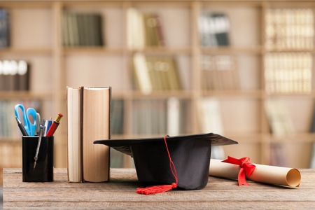 graduation cap, hat with degree paper on wood table graduation concept.の写真素材