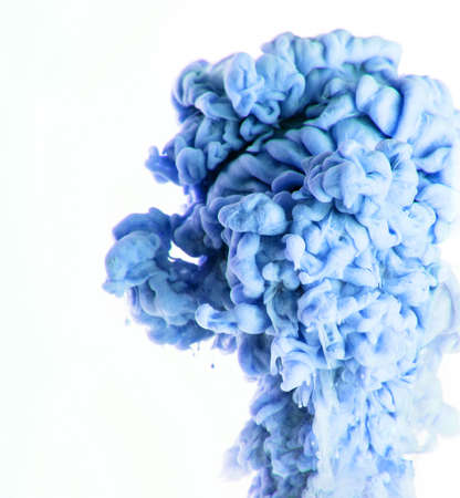 Color drop photographed in motion. Ink swirling in water isolated on white background.の写真素材