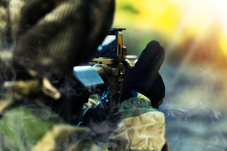 Soldier Taking Aim lying in grass, focus on gunの写真素材
