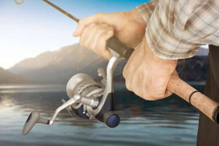 Fishing in river.A fisherman with a fishing rod on the river bank. Man fisherman catches a...
