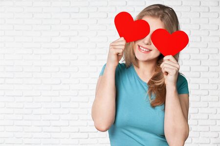 adorable girl with valentines day heart showing love fun affection portrait on grey backgroundの写真素材