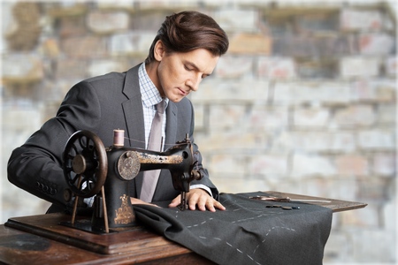 Tailors at work. Two confident tailors working at tailor shop
