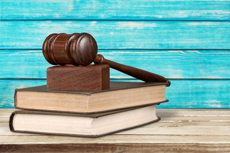 a wooden mallet and a book on a white background