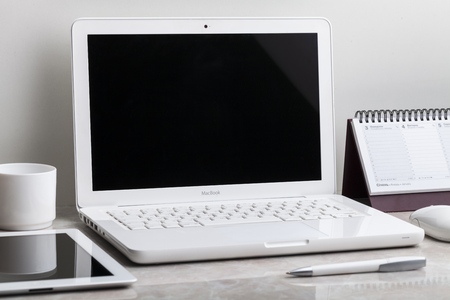 Laptop mockup with tablet computer, smartphone and notebook on the modern office desk. Consists of...