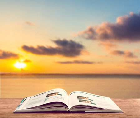 Detail of an old holy bible open with a beautiful and mystical sky in the background in a golden lightの写真素材