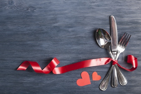 Kithcen cutlery and decorative paper hearts, on dark grey backgroundの写真素材