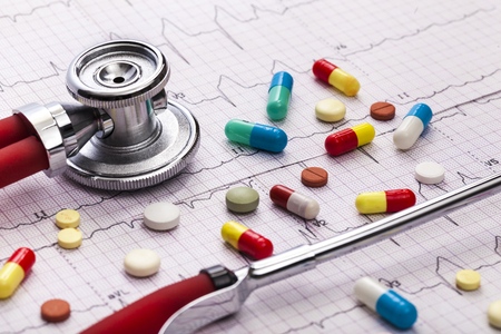 several tablets lie on an ekg. symbolic photo for diseases of the heart and circulation