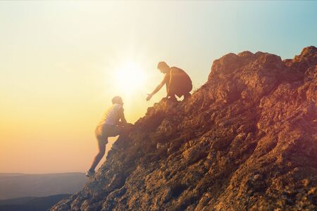 People helping each other hike up