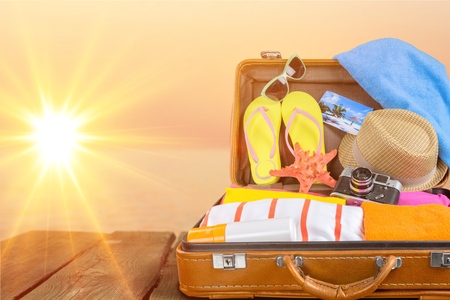 Beach accessories In open suitcase on beachの写真素材