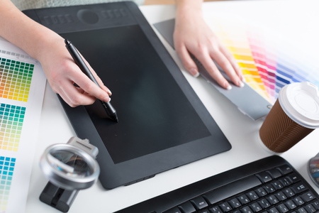 Graphic design, printing, advertising Graphic designer working with digitizer, magnifier, pantone...