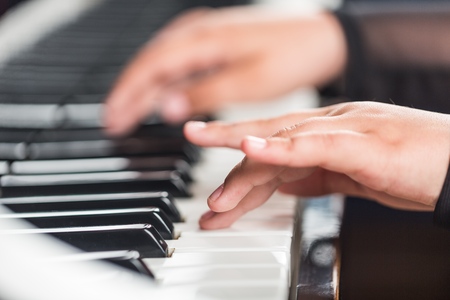 Children's fingers on the keys of a piano playing/Etude