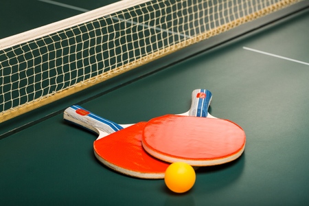 Table Tennis Rackets and Ball on Table with Netの写真素材