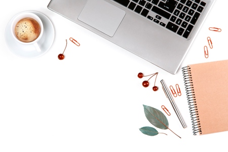 Flat lay, top view office table desk. Workspace with notebook, laptop, coffee cup, scissors and clips on white background.の写真素材