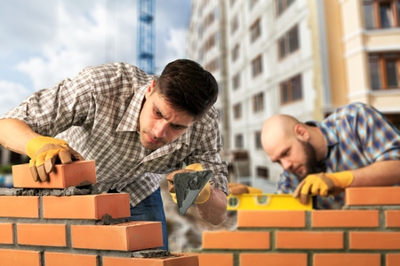 Bricklayer worker installing brickの写真素材