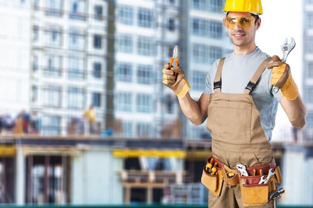 business, building, teamwork and people concept - group of smiling builders in hardhats at...