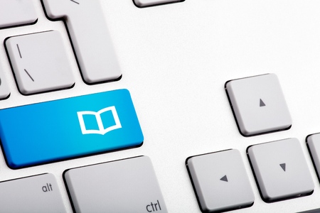 Blue Bottom on a Laptop with Open Book - Close Upの写真素材