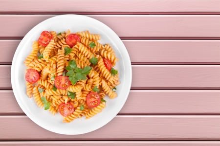 Spaghetti pasta with tomatoes and parsley on  table.