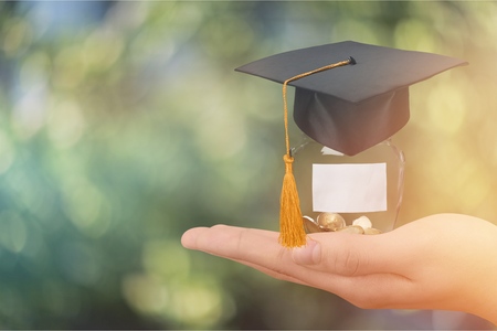 Hand holding coins in glassの写真素材