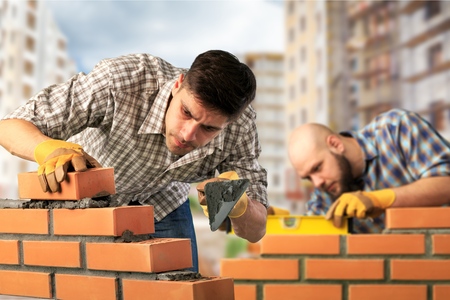 Bricklayer worker installing brickの写真素材