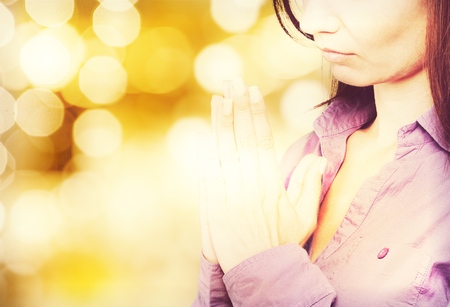 Closeup portrait of a young caucasian woman praying
