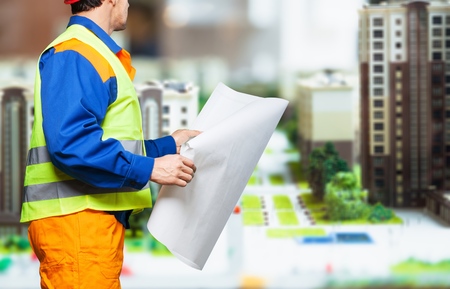 business, building, teamwork and people concept - group of smiling builders in hardhats at...