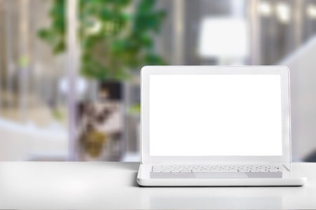 Computer notebook and mouse with a coffee shop behind the scenes Blur coffee shop, Blur restaurant sun flare effect photo.の写真素材