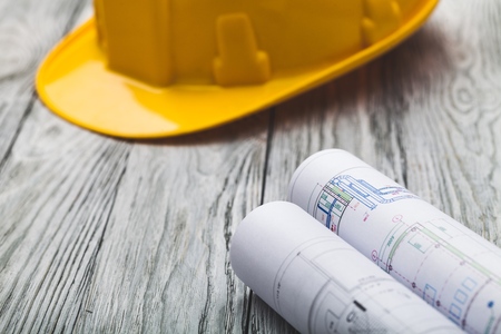 Hard hat construction plans on wooden board building concept.の写真素材