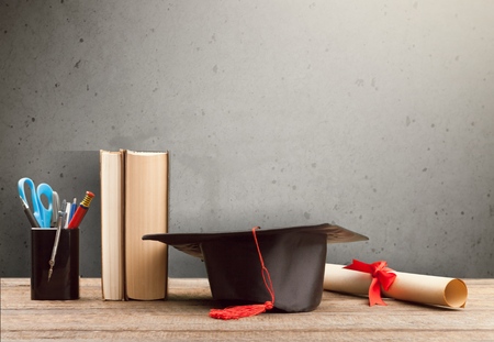 graduation cap, hat with degree paper on wood table graduation concept.の写真素材