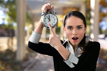 Frustrated young businessman holding an alarm clockの写真素材