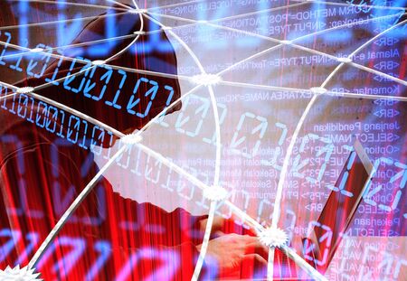 Internet crime concept. Hacker working on a code on dark digital background with digital interface around.の写真素材