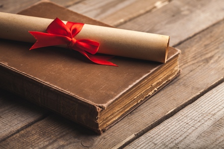 graduation cap, hat with degree paper on wood table graduation concept.の写真素材