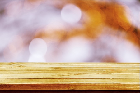 Image of wooden table in front of abstract blurred restaurant lights background.