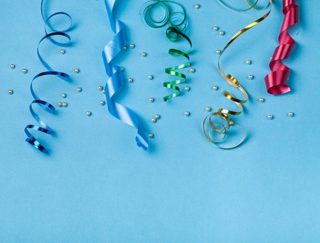 Colorul party streamers on blue background. Celebration concept. Flat lay.の写真素材