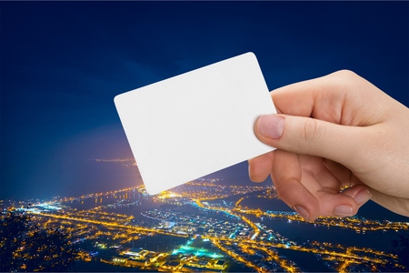 Empty card in hand on city background