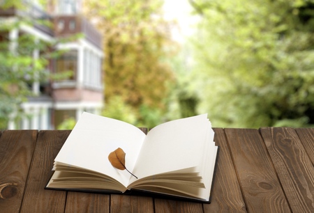 Open book on wood planks over outdoor natural background