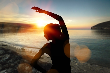 Woman meditation on sunset background