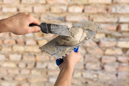 Hands Plasterer at work. Application of the plaster on the wall. textured plaster