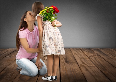 Happy mothers day! Child daughter congratulates moms and gives her a postcard and flowers tulipsの写真素材