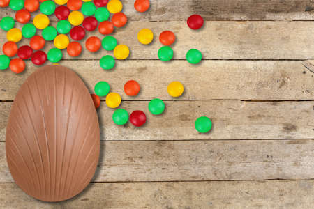 Easter composition with chocolate eggs on color wooden background, space for textの写真素材