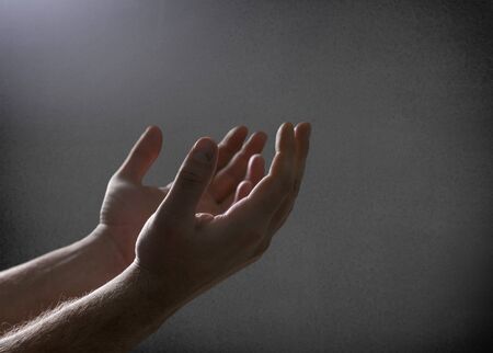 Silhouette rosary against cross in hand. Background sunriseの写真素材