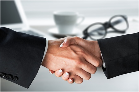 Close-up image of a firm handshake between two colleagues after signing a contractの写真素材