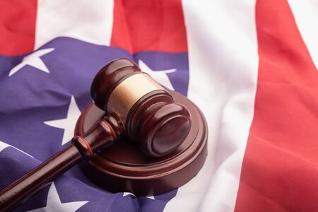 Judges wooden gavel with US flag in the background. Symbol for jurisdiction.の写真素材