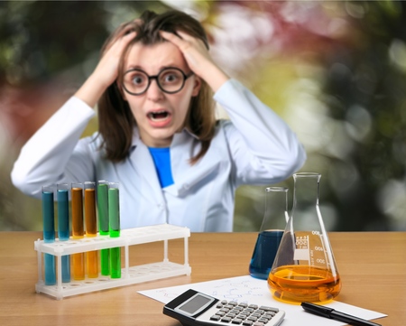 Young woman biologist in white coat holding test tubeの写真素材