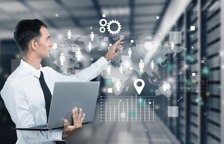 Businessman holding laptop and touching icons on background