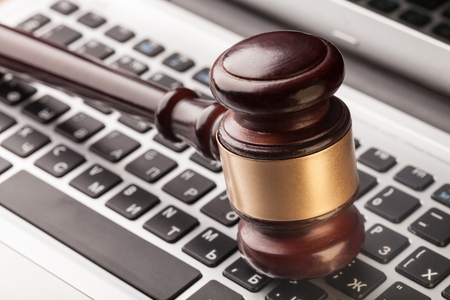 Wooden judge gavel on laptop computer, cyber law or crime concept